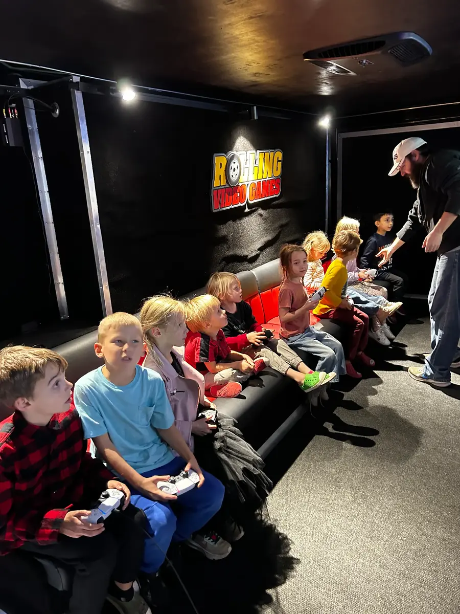 Children gaming side by side on the trailer couches
