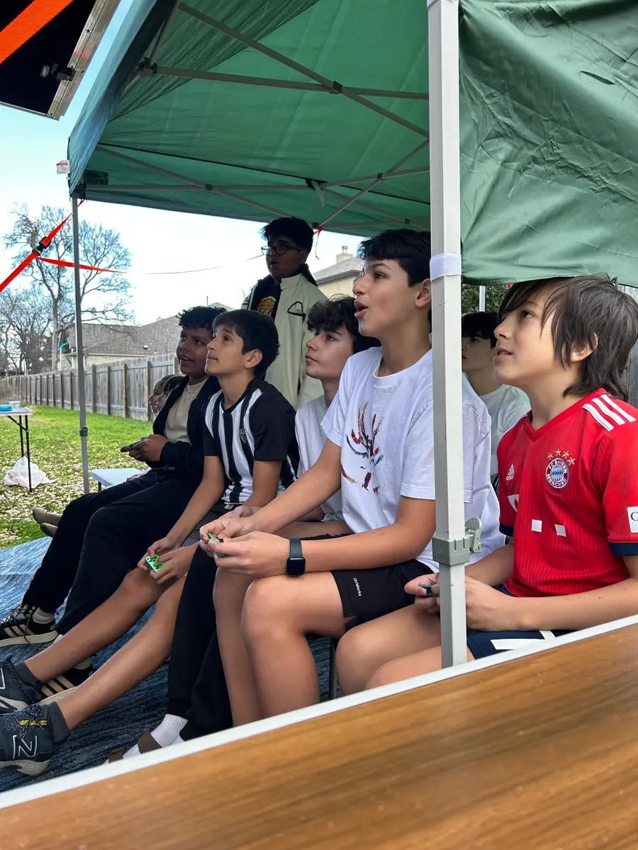 Teens playing a match under the outdoor canopy