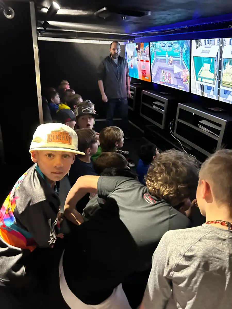 Players focused on a multiplayer game inside the trailer